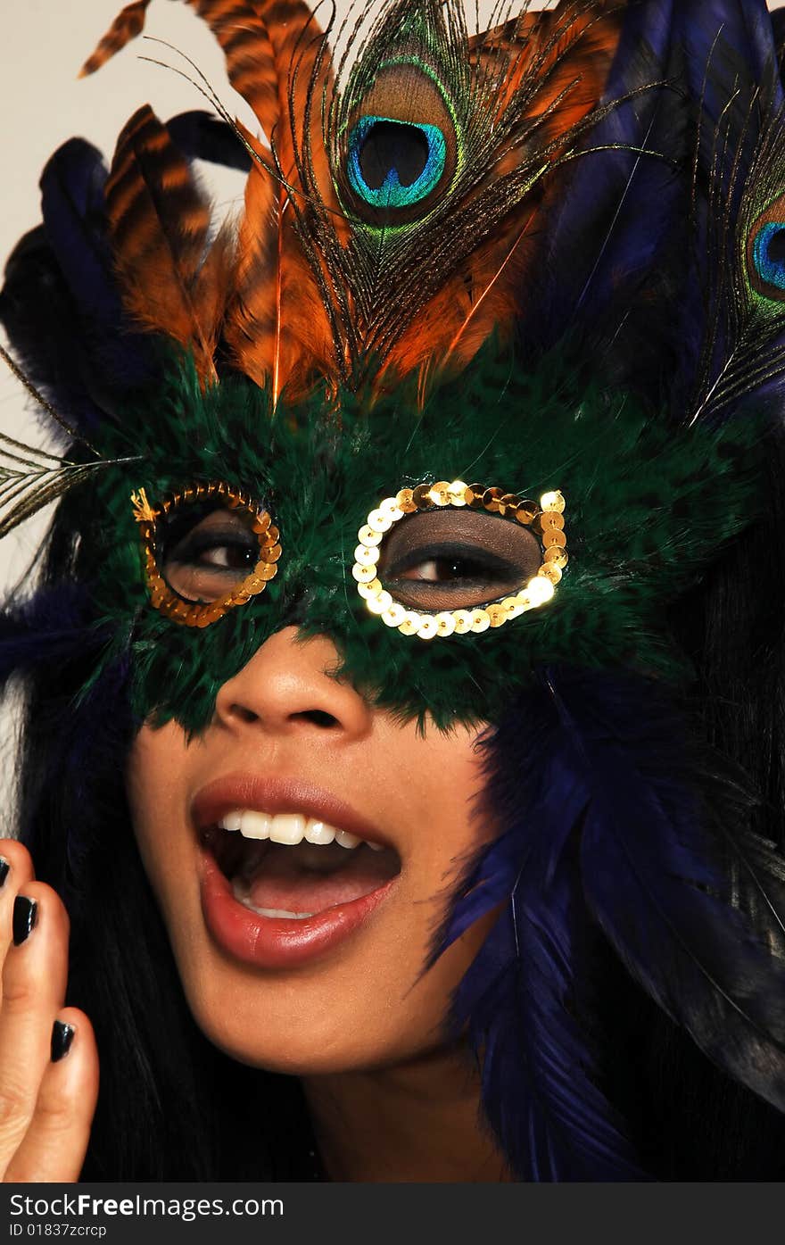 Close-up portrait of a young Asian girl with a colorful mask. Close-up portrait of a young Asian girl with a colorful mask.