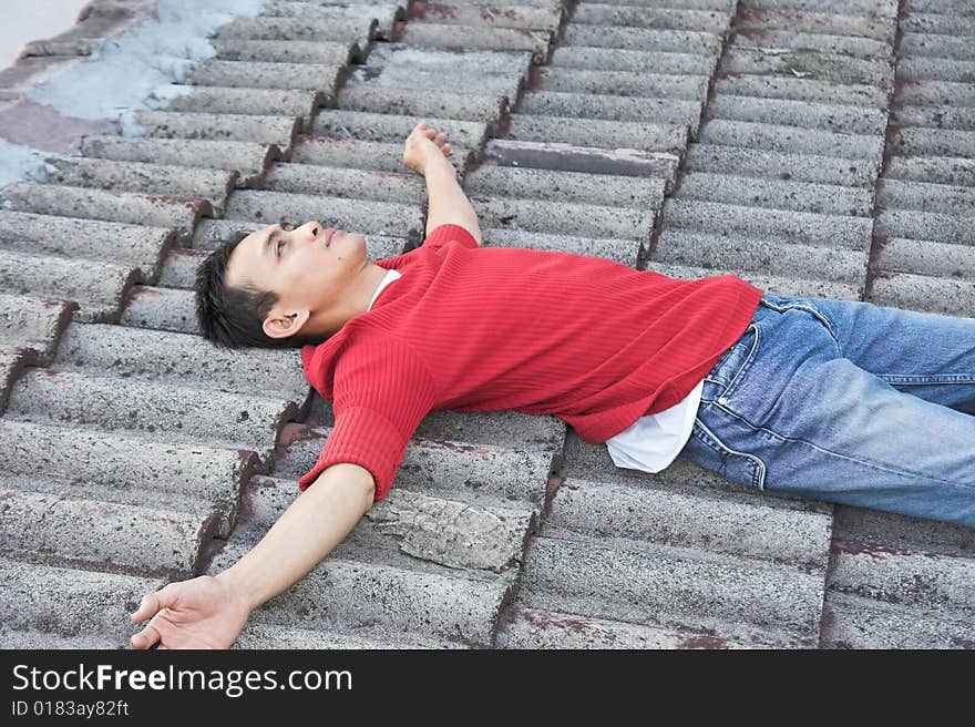 Man lie down on the roof tile. Man lie down on the roof tile