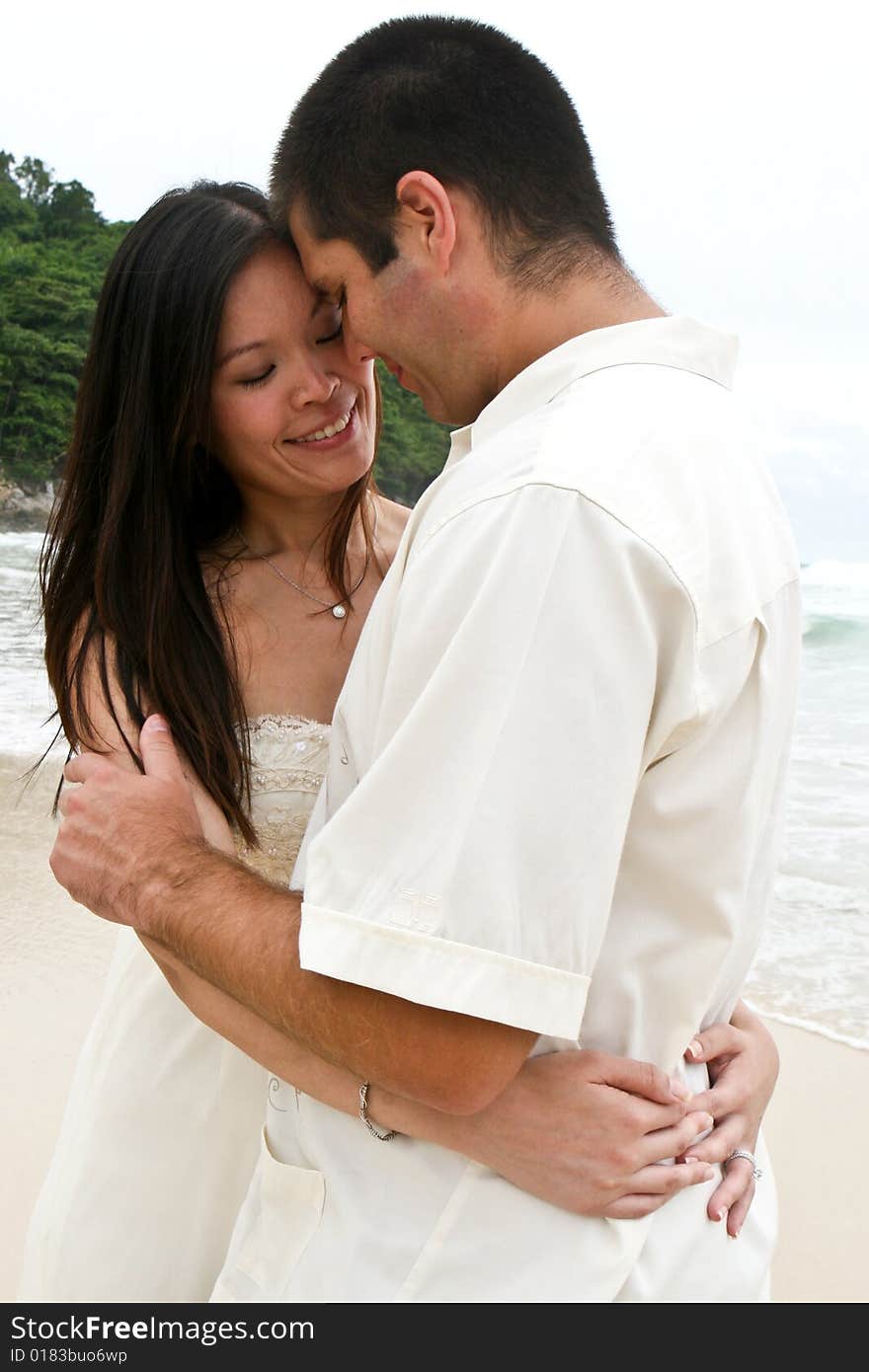 Portrait of an attractive bride and groom on the beach. Portrait of an attractive bride and groom on the beach.