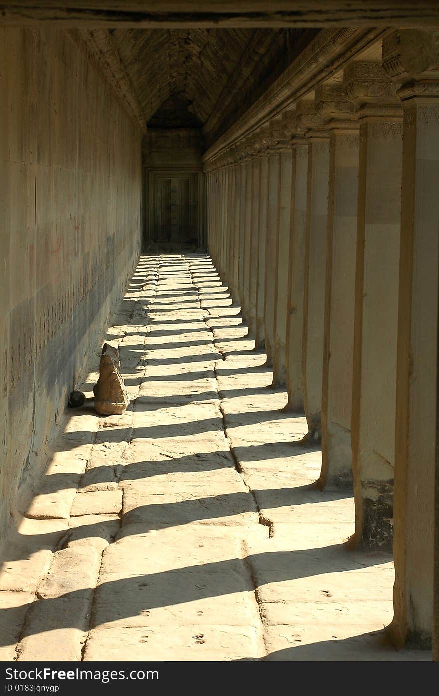 A porch bordered by colonnades with shadows in Angkor,Cambodia