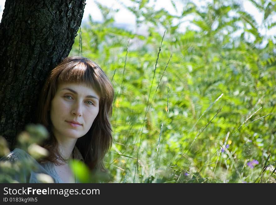 The Girl Under A Tree Looks In The Cam