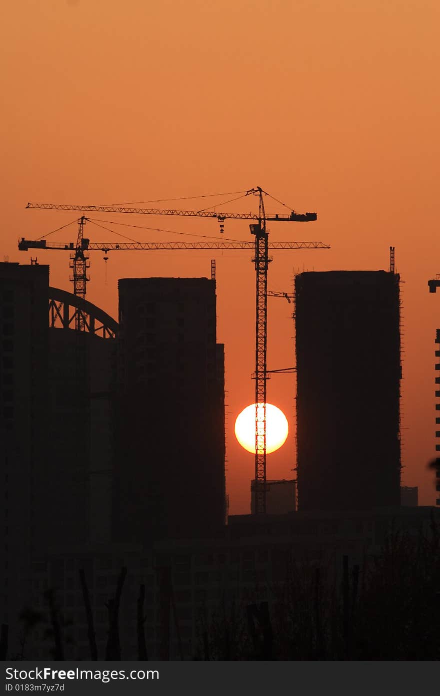 Tower Cranes And Setting Sun