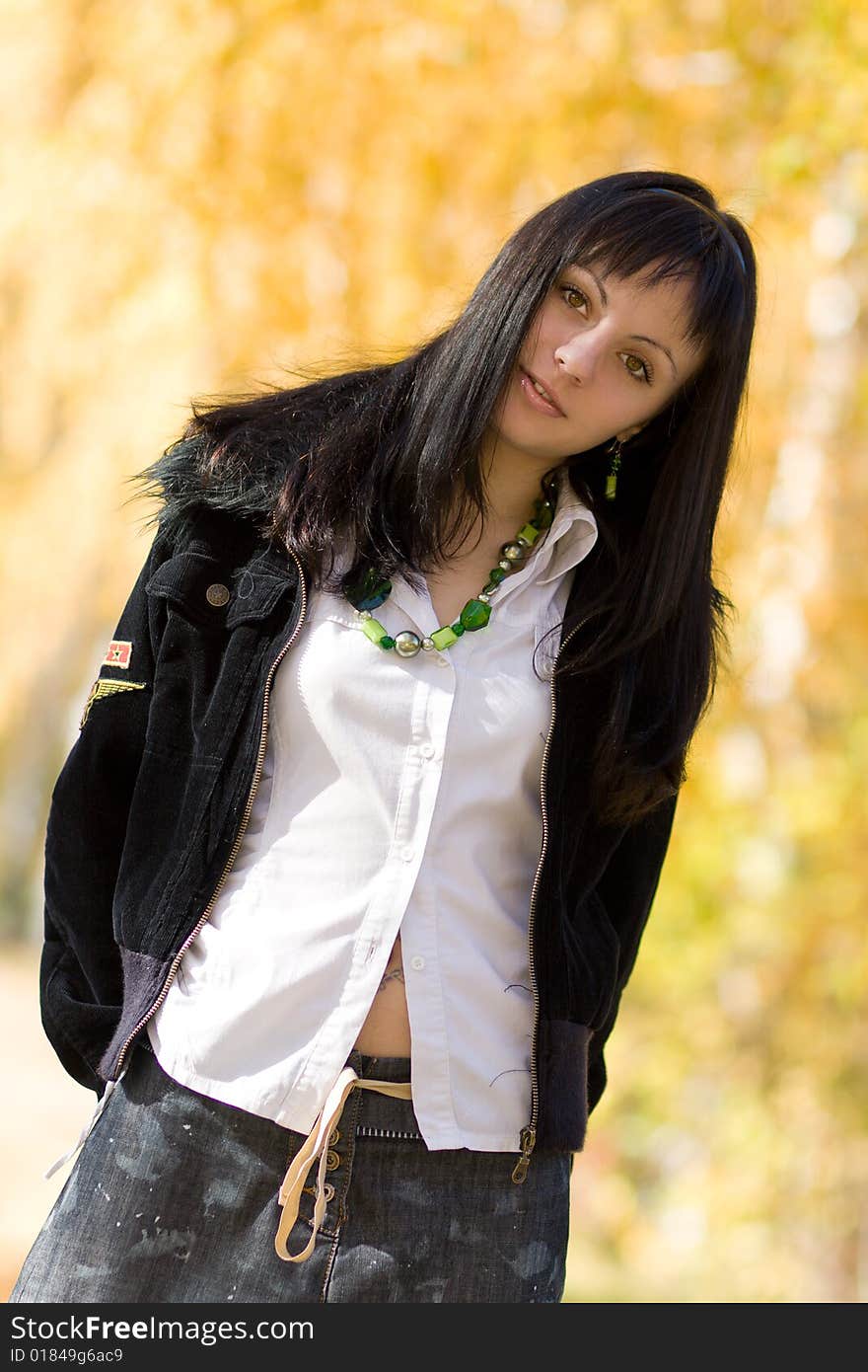 Young beautiful woman in the park over yellow autumn background. Young beautiful woman in the park over yellow autumn background