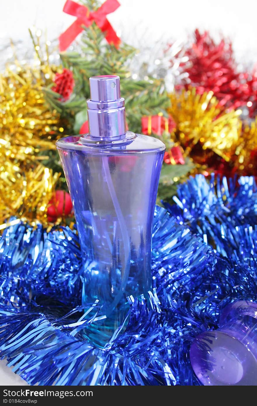 Perfume near a fur-tree and New Year's ornaments. Perfume near a fur-tree and New Year's ornaments