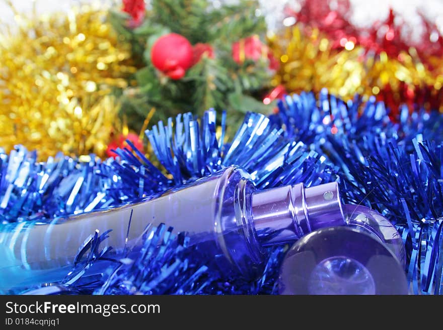 Perfume near a fur-tree and New Year's ornaments. Perfume near a fur-tree and New Year's ornaments