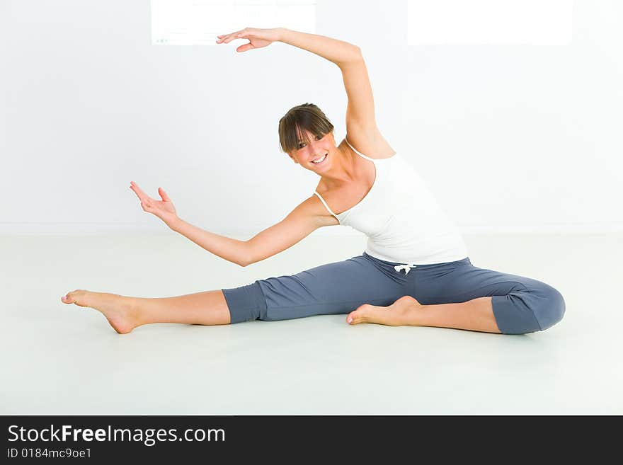 Young attractive woman doing fitness exercise. She's looking at camera. Front view. Young attractive woman doing fitness exercise. She's looking at camera. Front view.