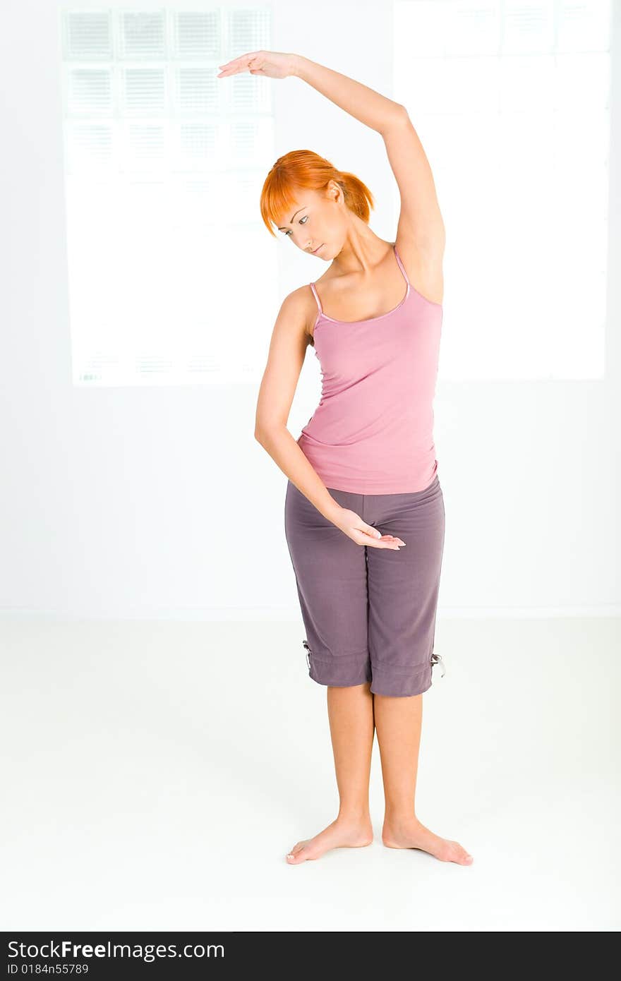 Young red-haired woman doing fitness exercise.  Front view. Young red-haired woman doing fitness exercise.  Front view.