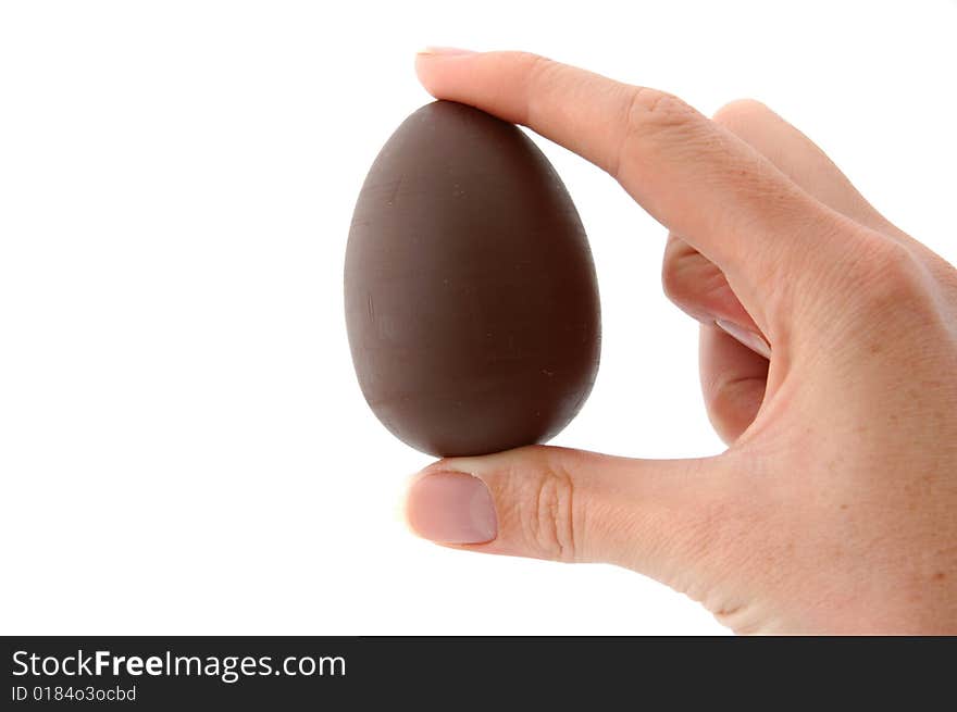 An Isolated to White photo of a mini Easter Egg with toy held between fingers. An Isolated to White photo of a mini Easter Egg with toy held between fingers