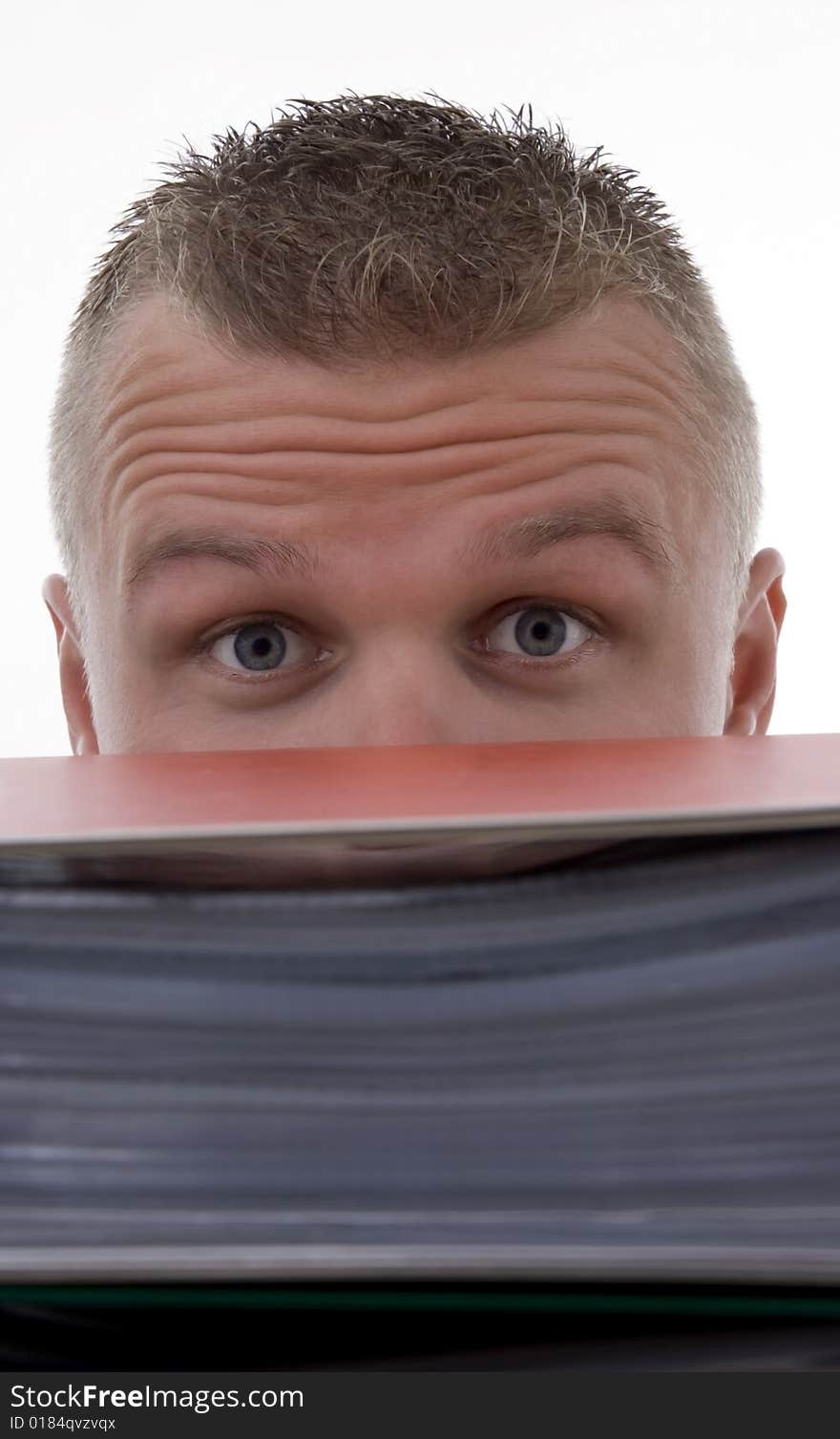 Man stashed  behind folders,with frown,against a white background.