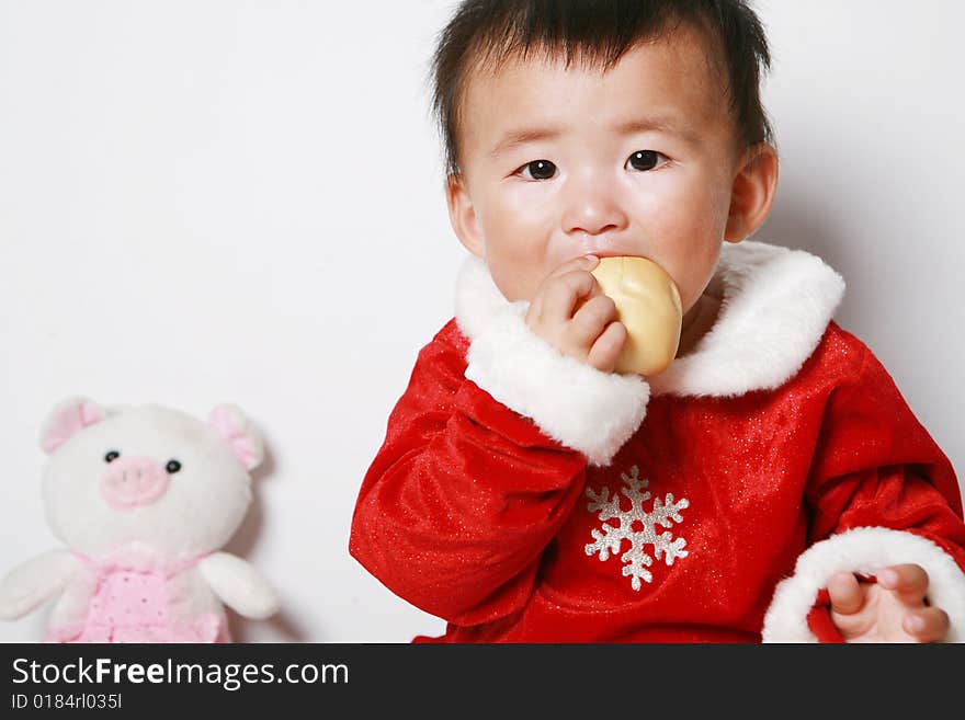 Santa baby in red dress, eating.