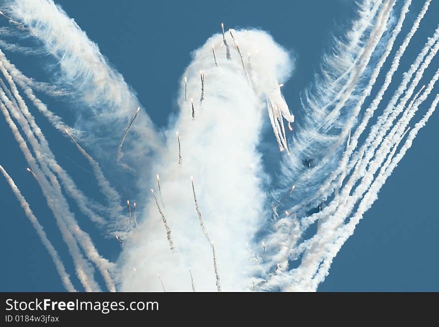 This abstract bird is photographed during celebratory aviashow. Day fireworks against the blue sky. This abstract bird is photographed during celebratory aviashow. Day fireworks against the blue sky.