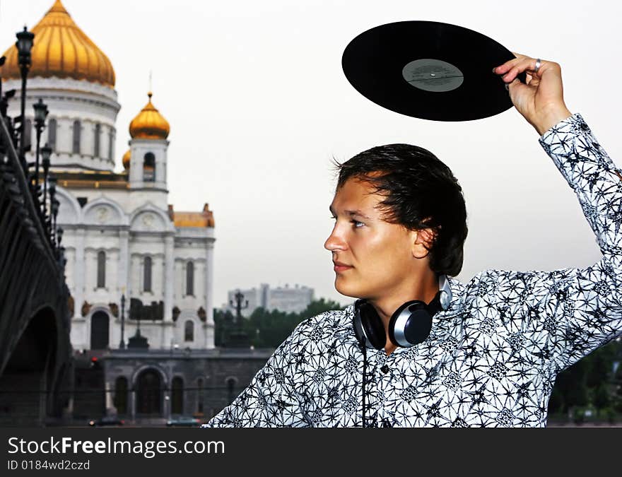 DJ Roman Kravtsov with his headphones holding vinyl over the head. DJ Roman Kravtsov with his headphones holding vinyl over the head