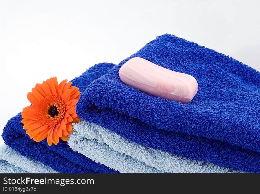 Blue towels, soap and flower on the white background