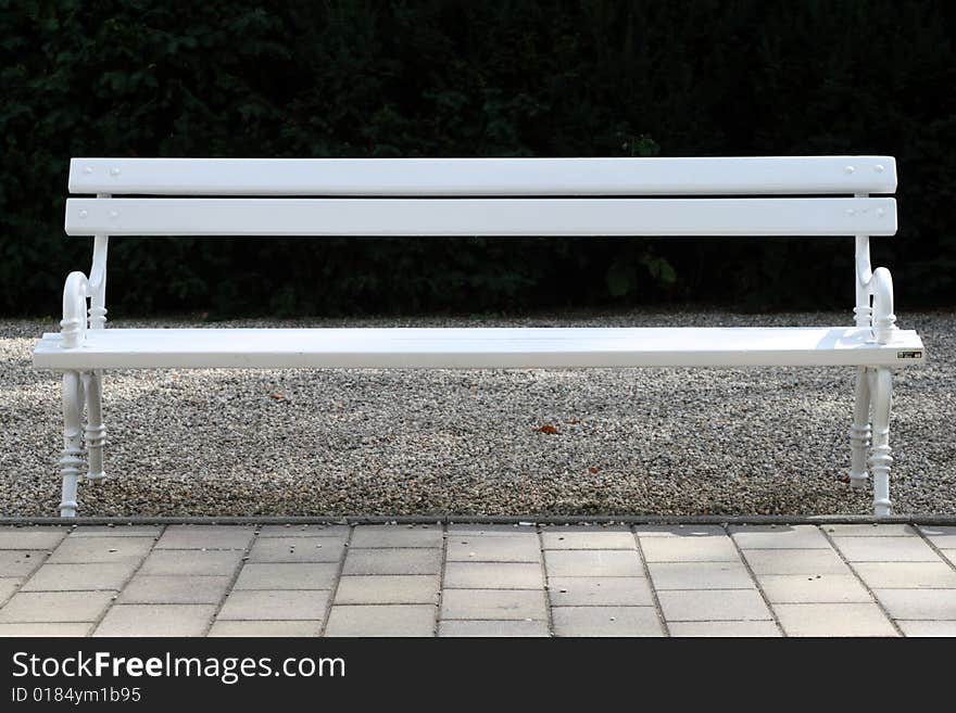 A light green bench in front of a dark background. A light green bench in front of a dark background