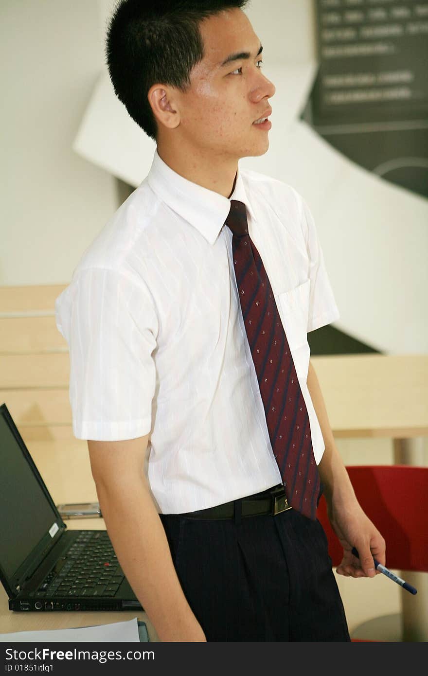 A young asian standing in office building. A young asian standing in office building