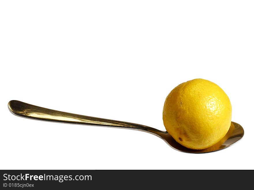 A yellow lemon on a spoon isolated on white with clipping path. A yellow lemon on a spoon isolated on white with clipping path