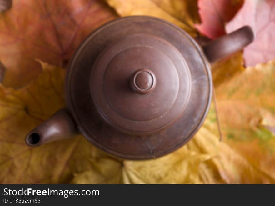 Tea pot on the yellow and red leafs. Tea pot on the yellow and red leafs.