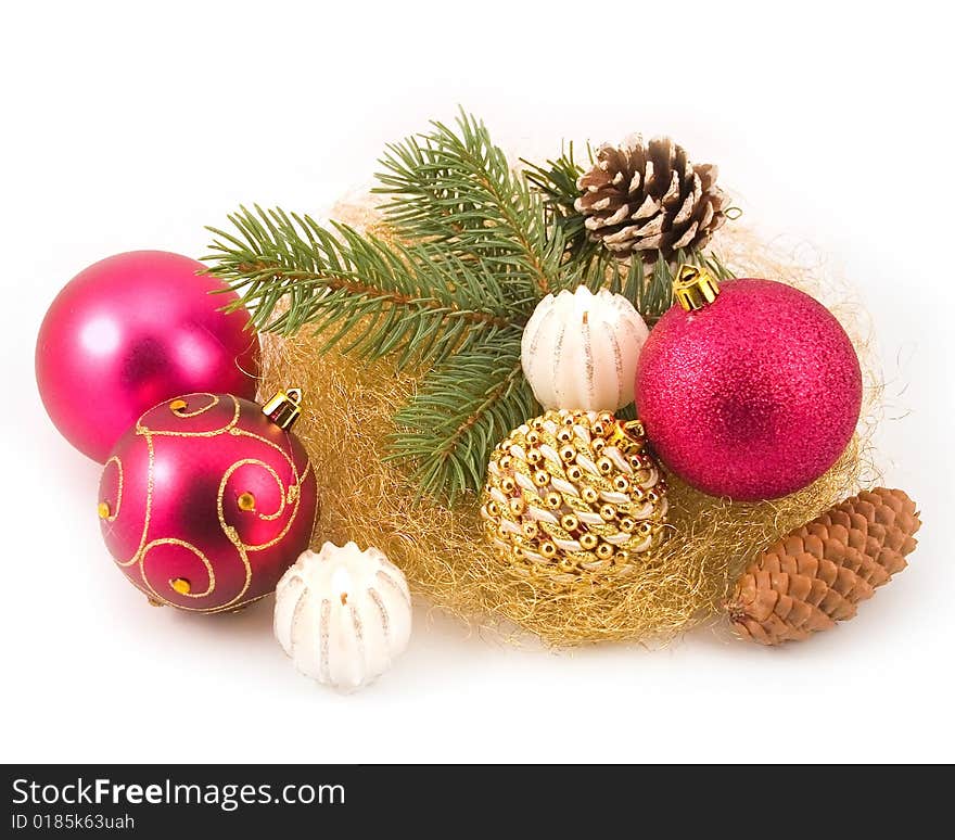 Gold tinsel with New Year's spheres and branches of fur-trees on white background