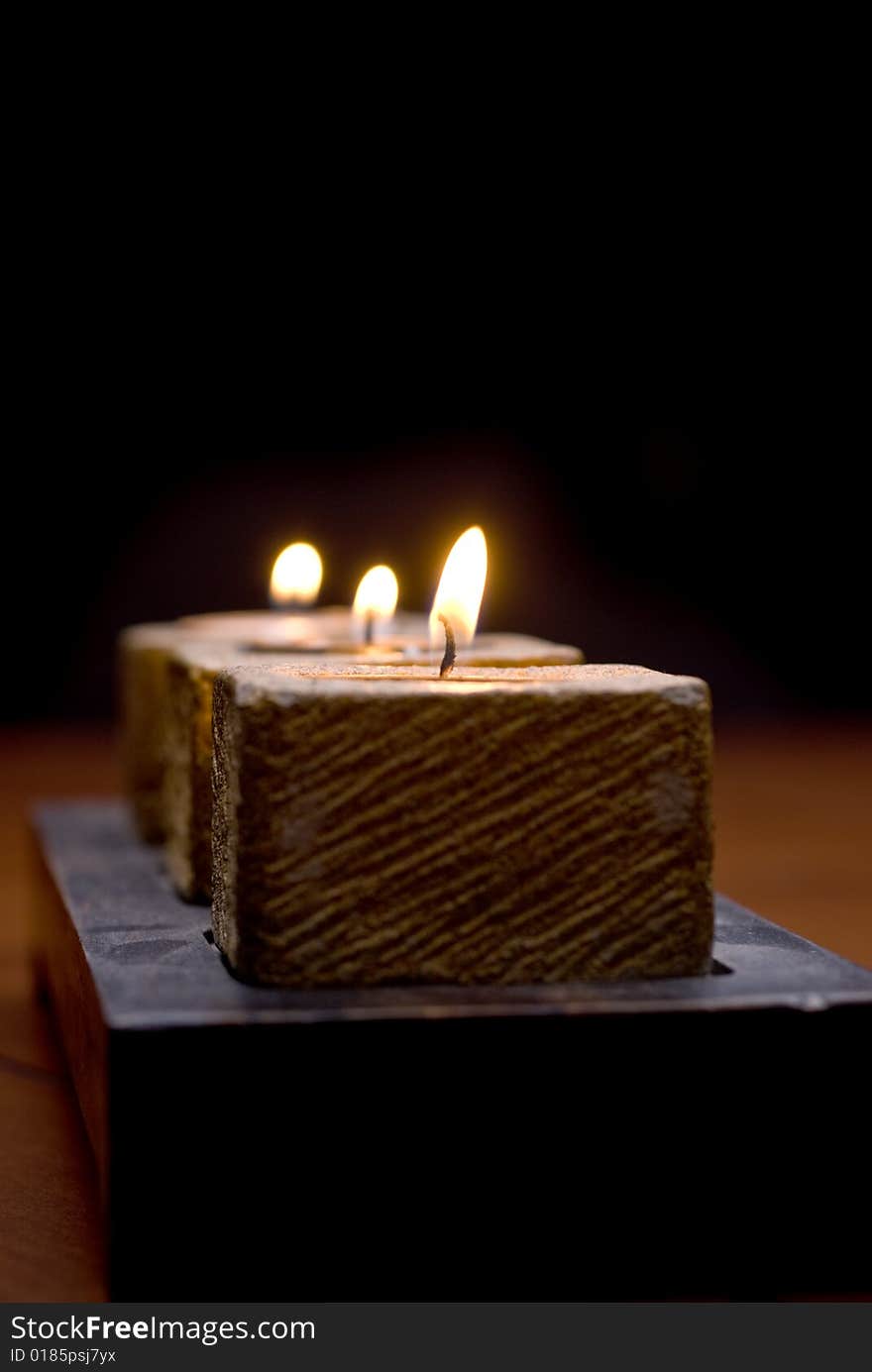 Trio of tea-light candles ona wooden table