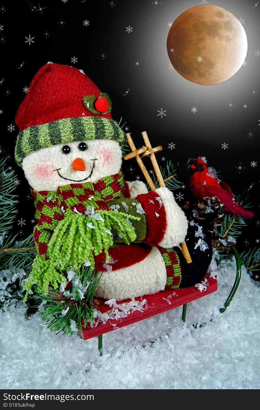 Christmas snowman on a sled under a full moon. Christmas snowman on a sled under a full moon.