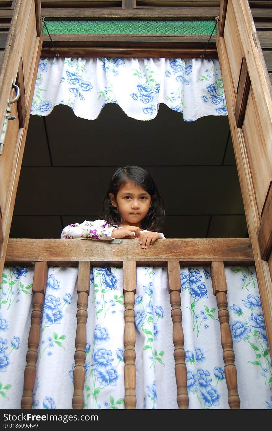 A Malaysian girl wearing malay  traditional clothe standing by window in a traditional malay house.