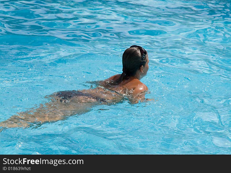 Young woman swims in a swimming pool. Young woman swims in a swimming pool