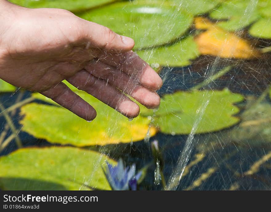 Hand and splashes of water in fountain