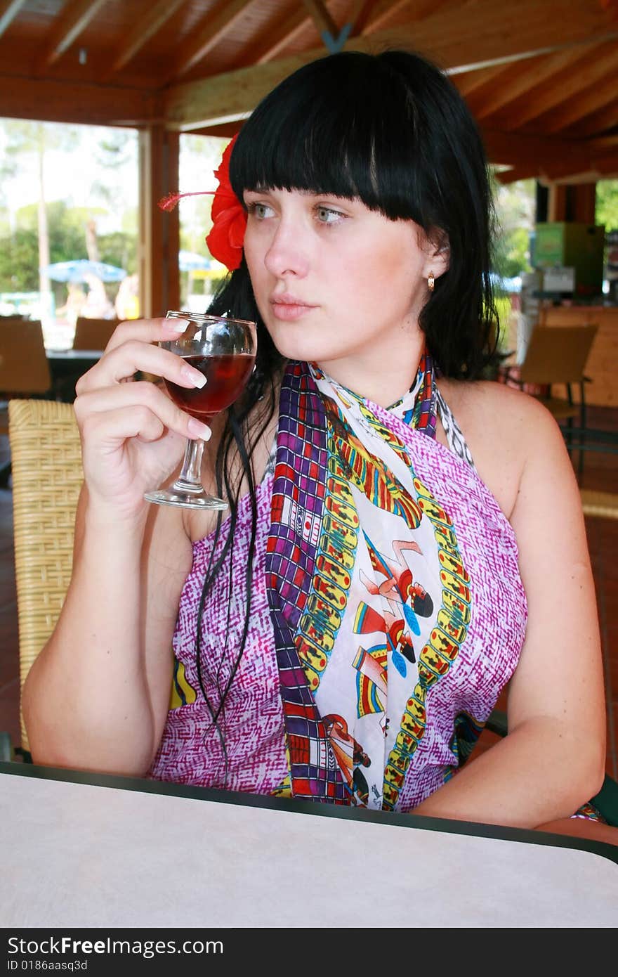 Girl the brunette with a flower and glass. Girl the brunette with a flower and glass