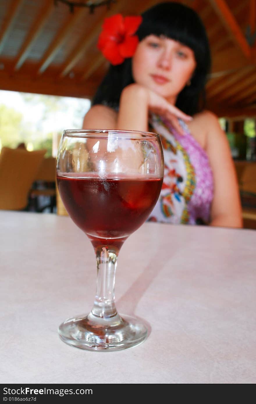 Girl the brunette with a flower and glass. Girl the brunette with a flower and glass