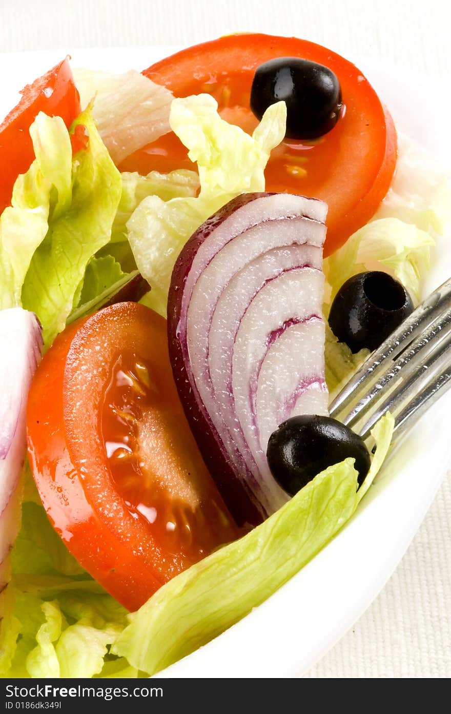 Fresh salad with lettuce, tomato, onion and olive