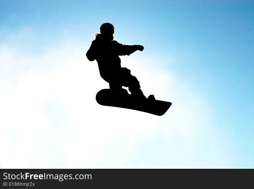 A snowboarder in action against blue sky