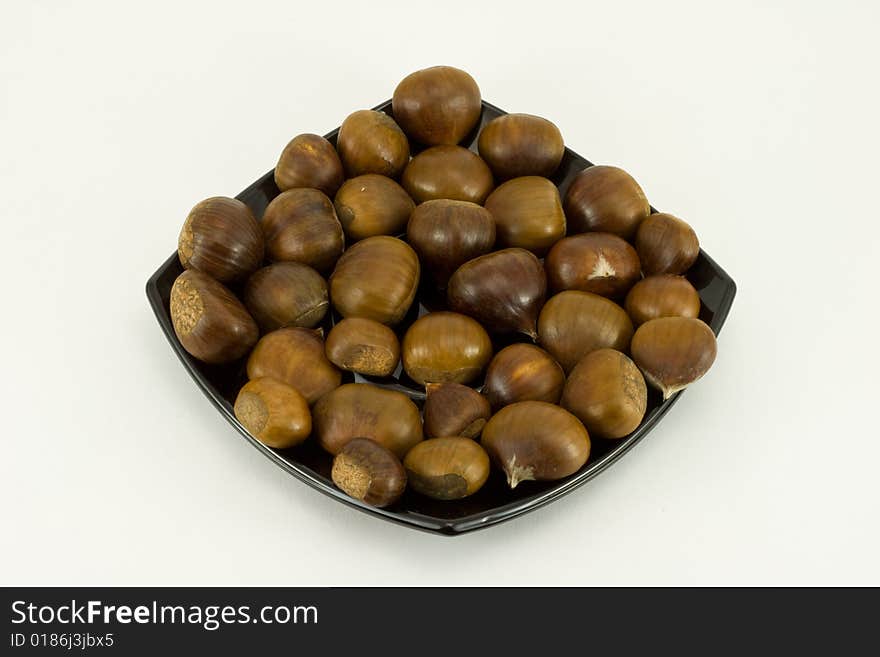 Chestnuts on dark plate isolat