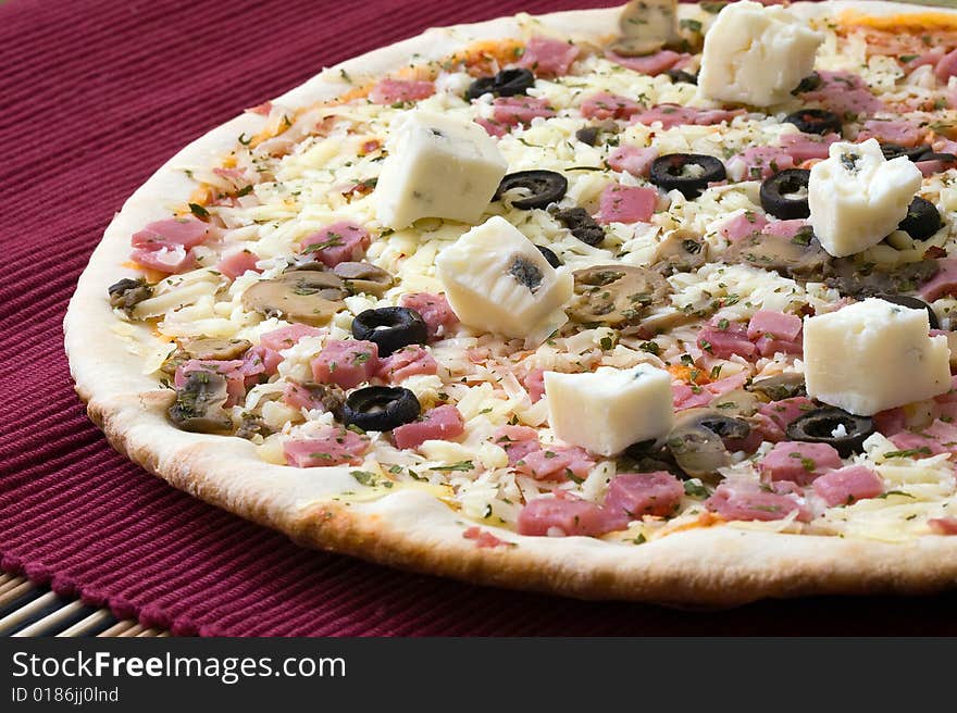 Tasty gorgonzola cheese pizza with black olives on red background