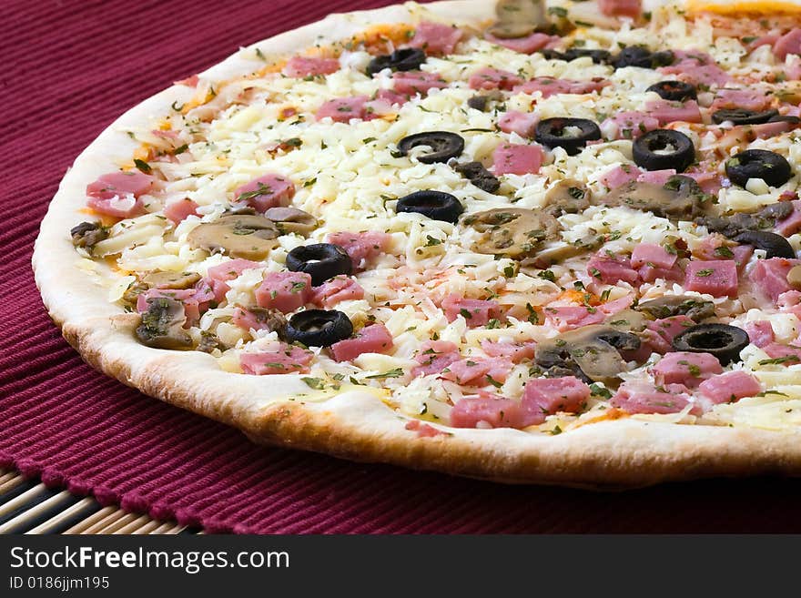 Tasty romana style pizza with black olives on red background