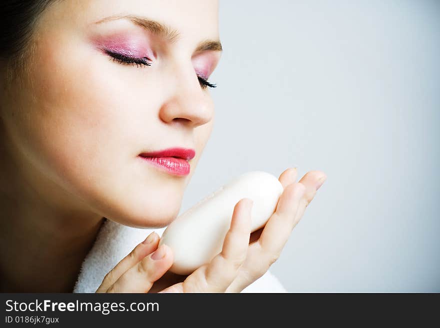 Beautiful woman in bathrobe smells a soap. Beautiful woman in bathrobe smells a soap.