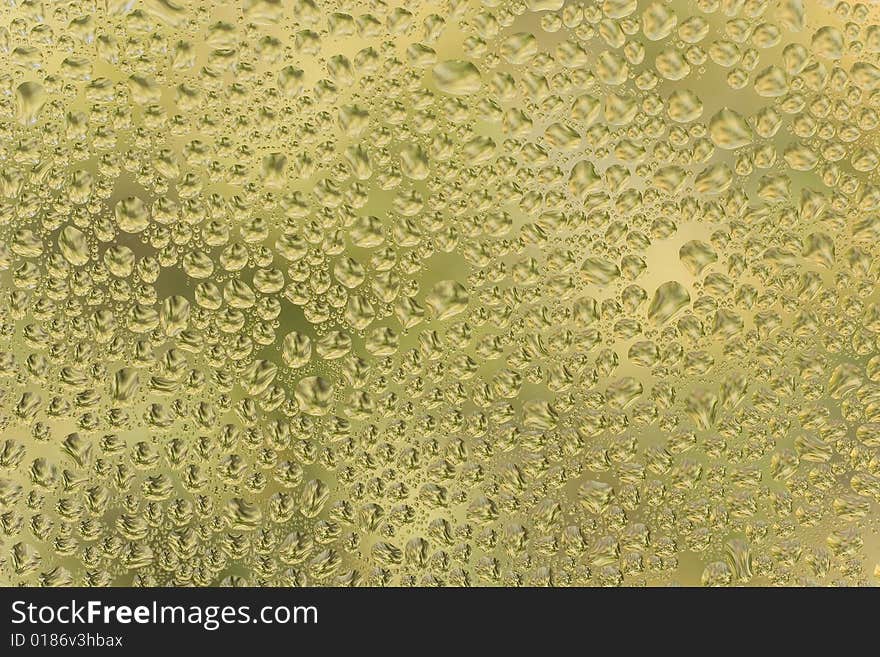 Abstract yellow background (raindrops on yellow glass)