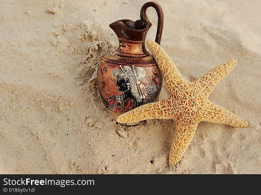 Star with a jug on sand