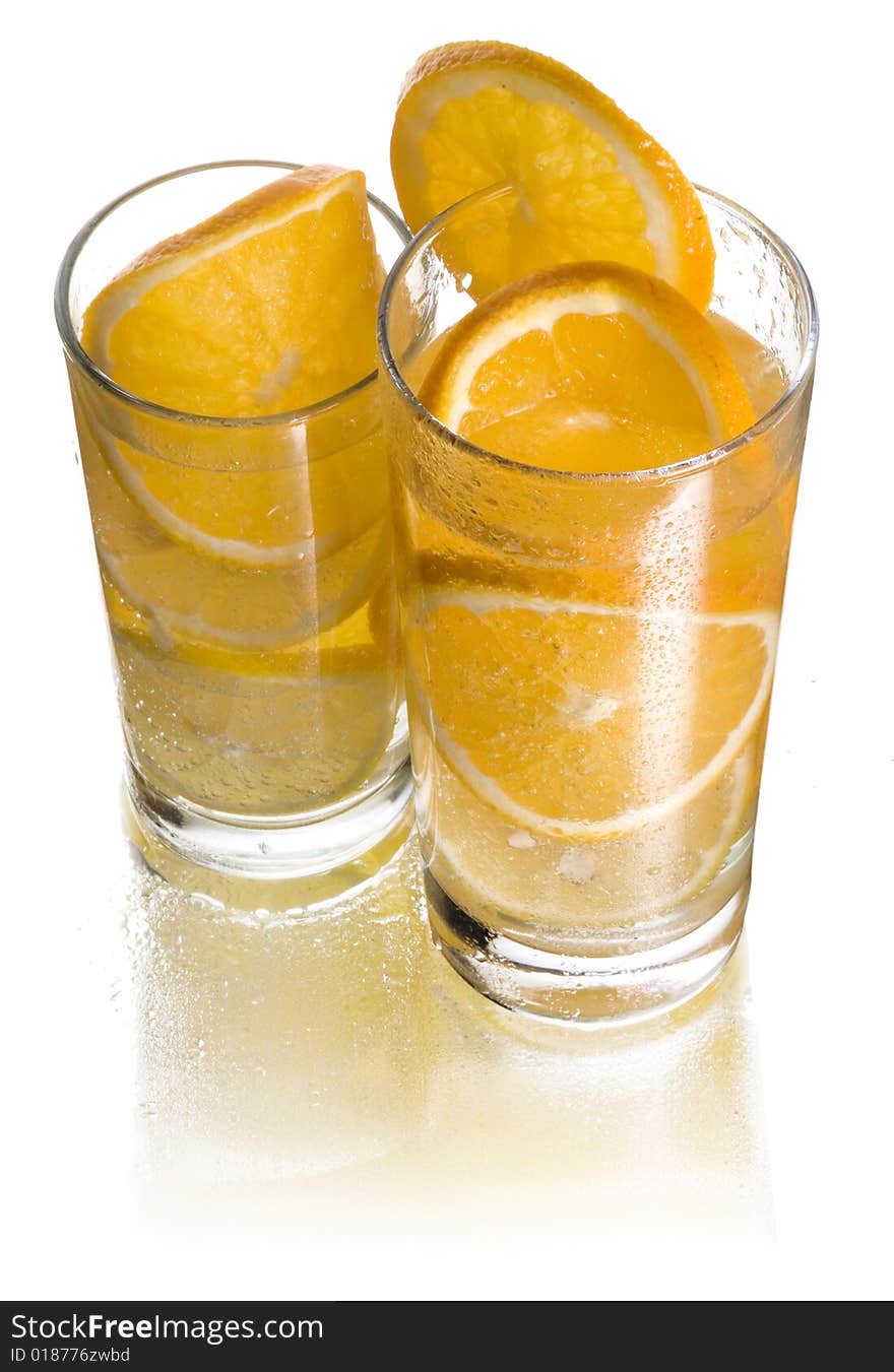 Two glasses of lemonade with orange and lemon. Two glasses of lemonade with orange and lemon