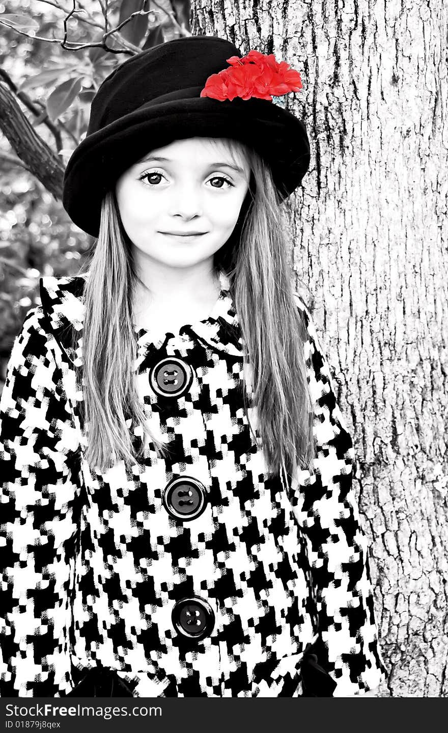 Little girl wearing a coat and a hat with a red flower. Little girl wearing a coat and a hat with a red flower