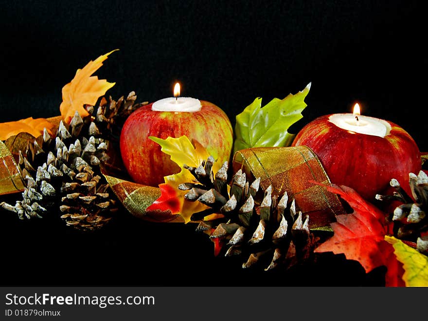 Glowing candles in apples with pine cones and ribbon. Glowing candles in apples with pine cones and ribbon.