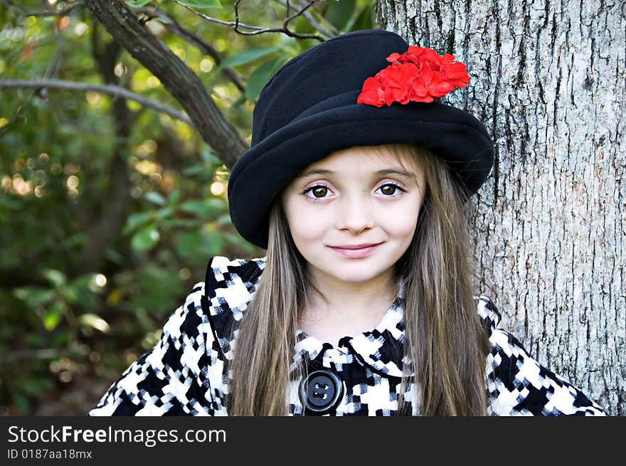 Close-up of little girl wearing a hat in an outdoor setting. Close-up of little girl wearing a hat in an outdoor setting.