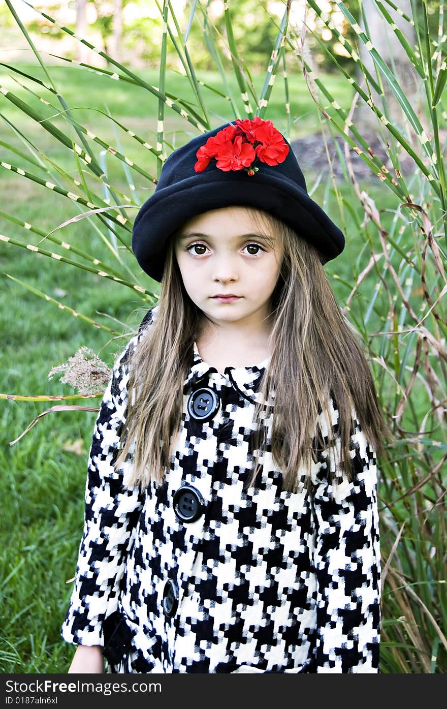 Little girl outdoors dressed in a coat and hat. Little girl outdoors dressed in a coat and hat.