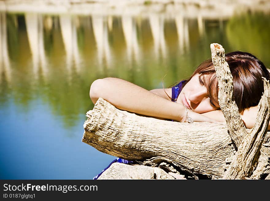 Young woman laying over old tree trunk. Young woman laying over old tree trunk.