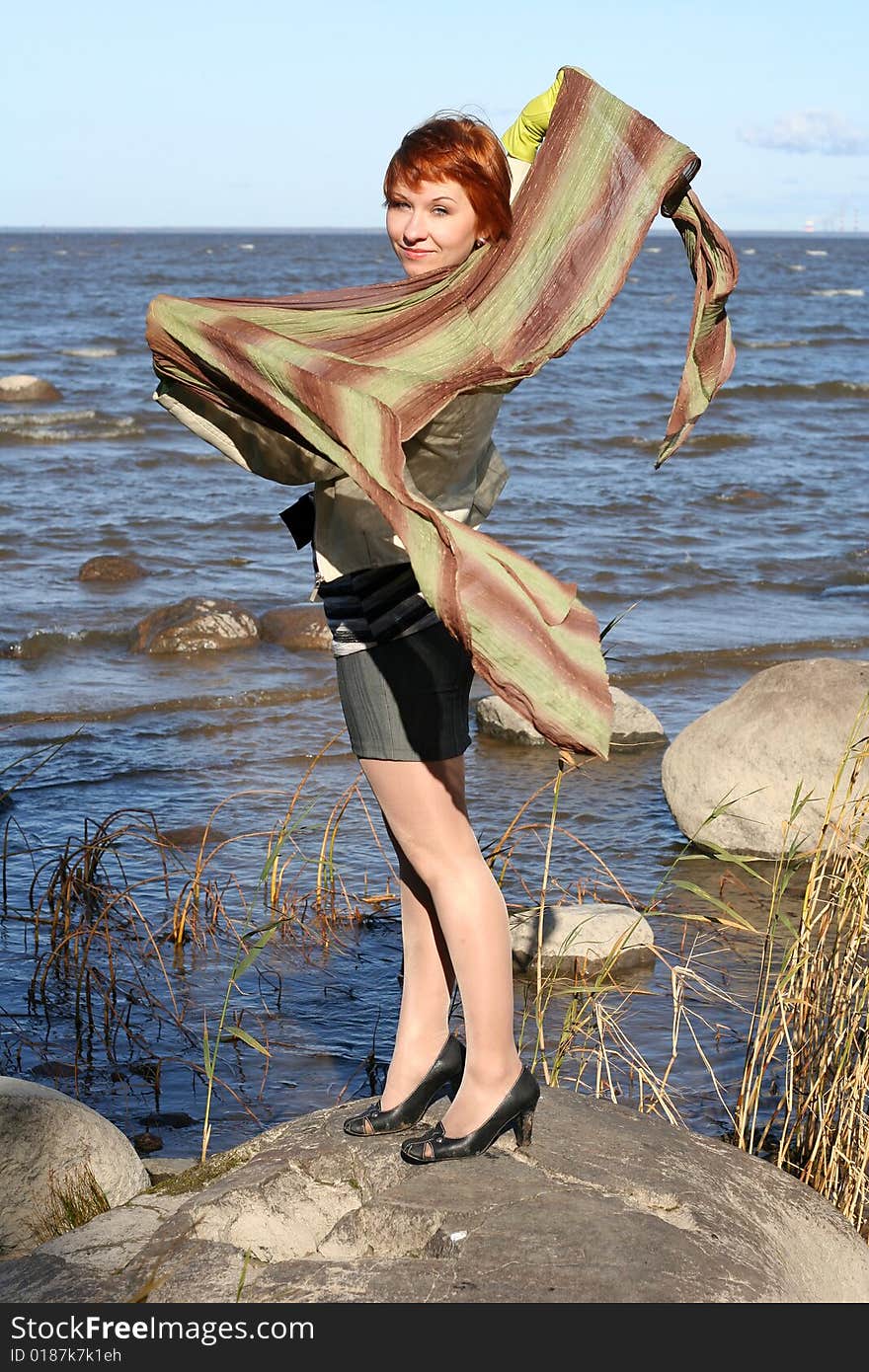 Red haired woman with scarf. Windy day.