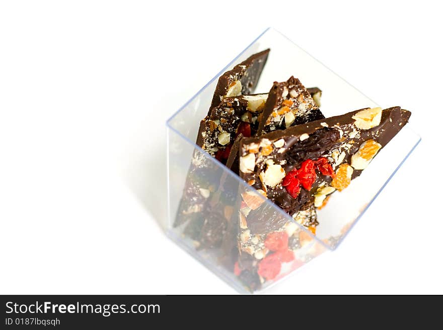 Glass bowl full of chocolate slices isolated on white background