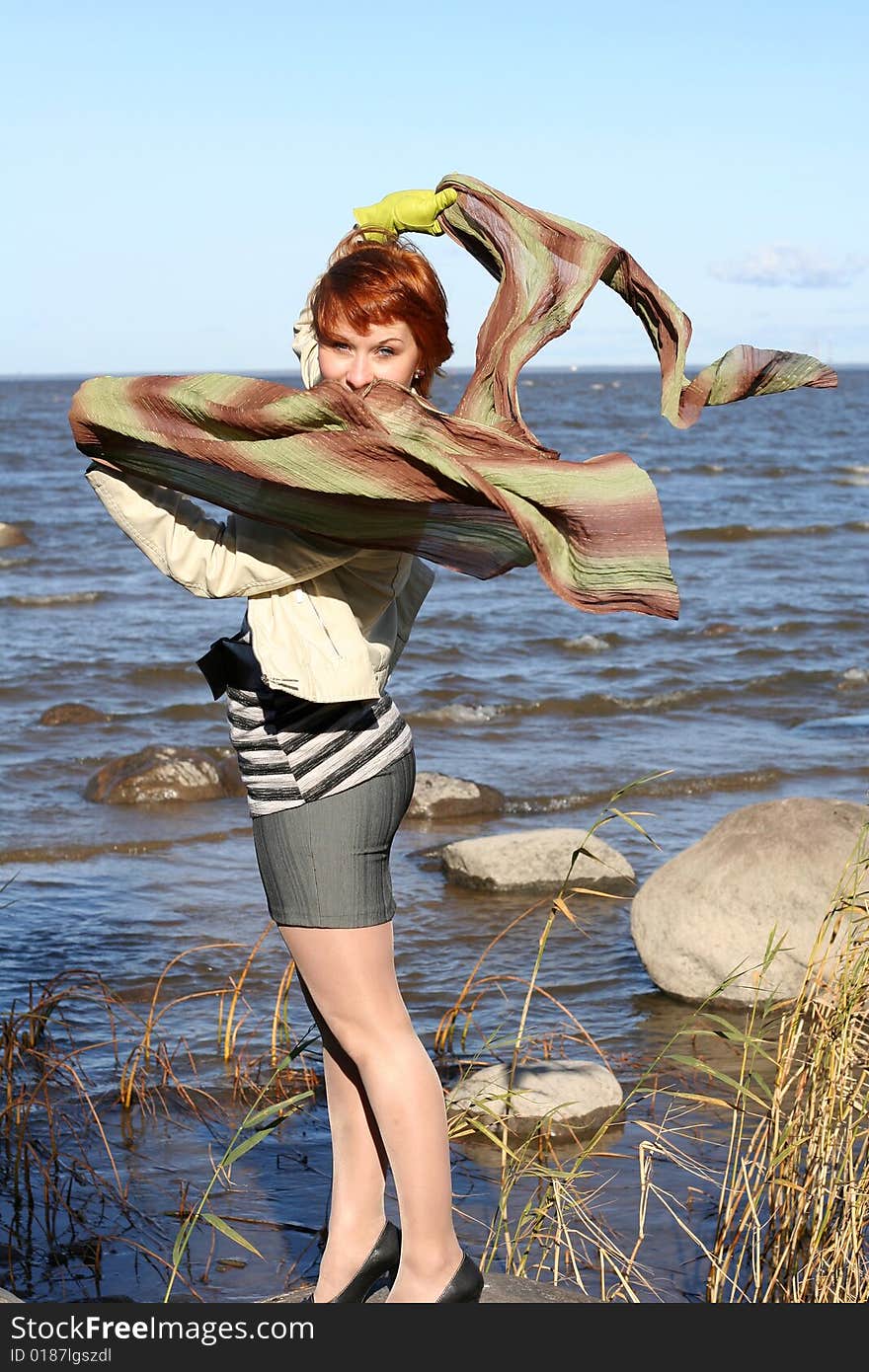 Red haired woman with scarf. Windy day.