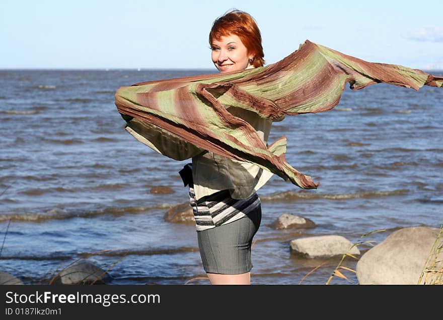 Red haired woman with scarf. Windy day.