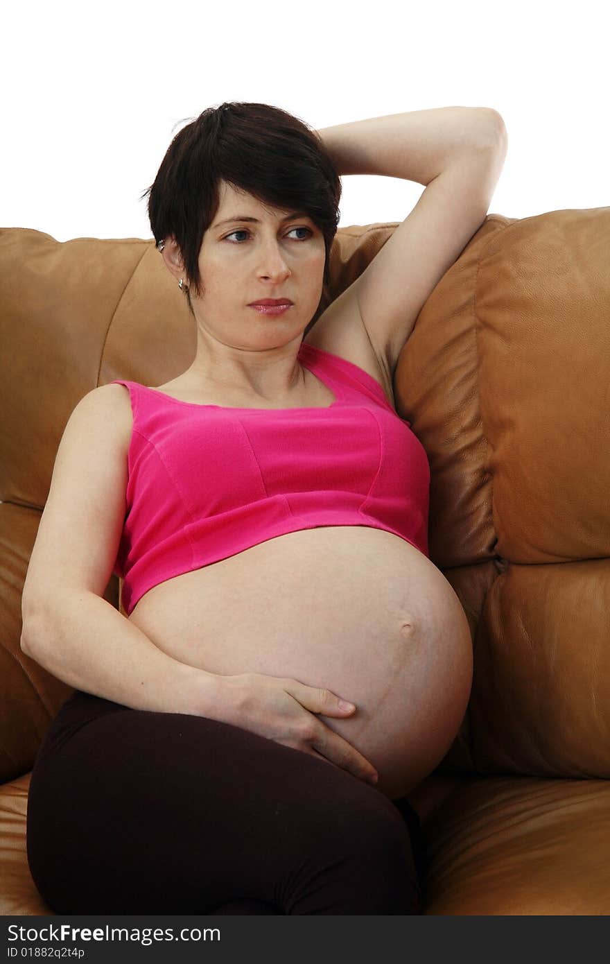 A pregnant woman sitting on a couch