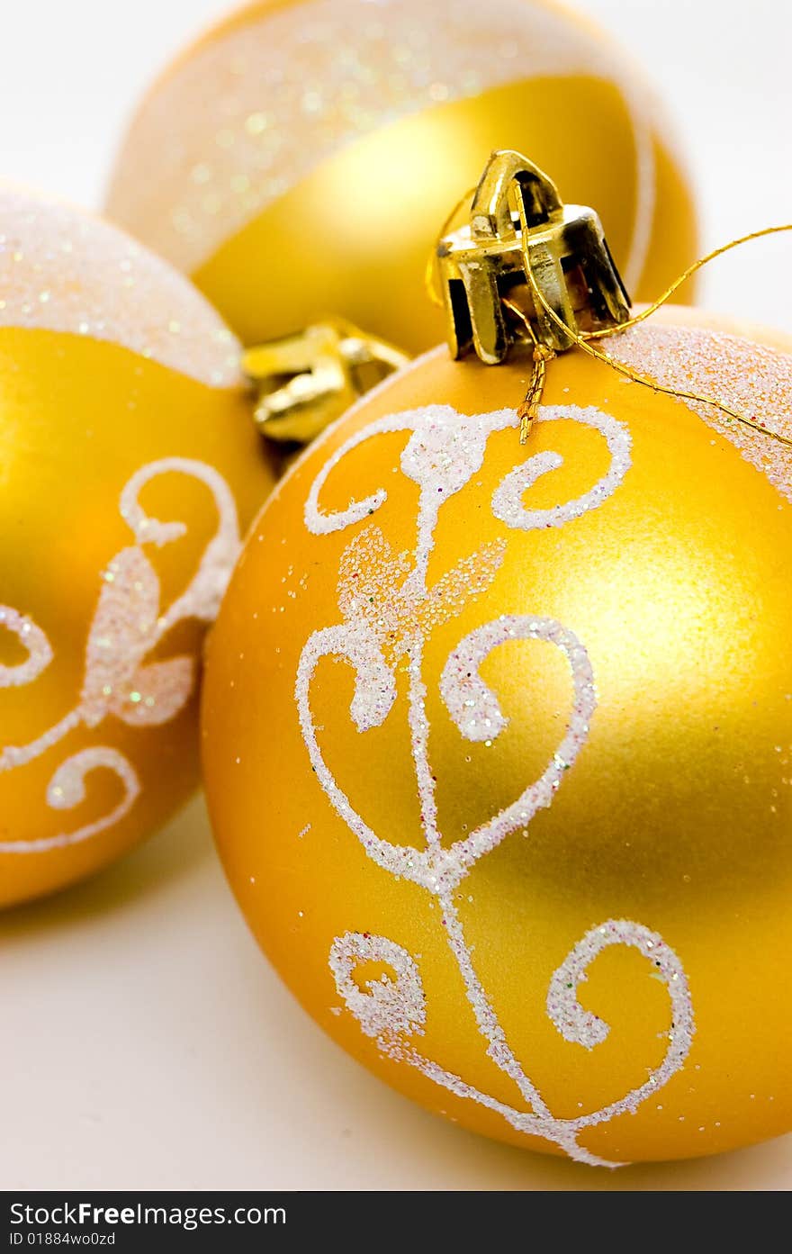 Closeup of three golden christmas balls over white. Closeup of three golden christmas balls over white