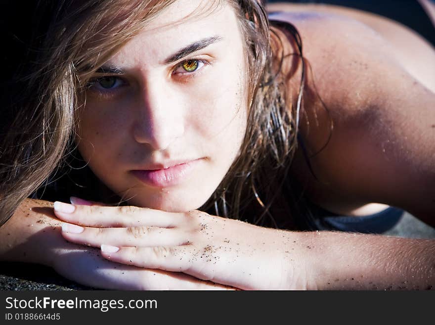 Green eyed beauty laying over the sand. Green eyed beauty laying over the sand